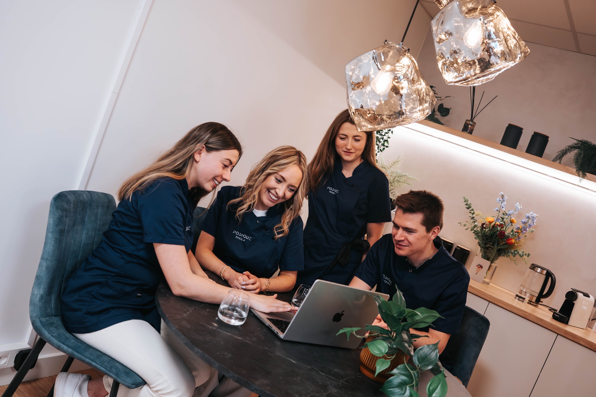 Het Podique-team overlegt samen rond de laptop